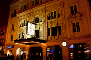 Ein gelbes Gebäude mit einem weißen Schild, auf dem 'Metro' steht, über Geschäften im Erdgeschoss.