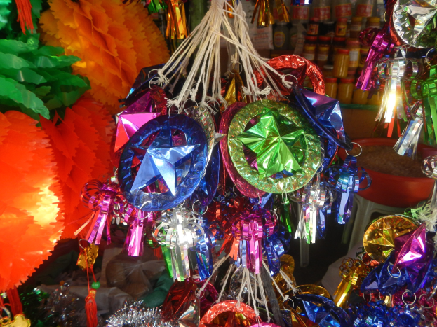 Farbenfrohe Festschmuck, einschließlich Laternen und Bändern, hängt von der Decke über Regalen mit Flaschen in einer feierlichen Atmosphäre.