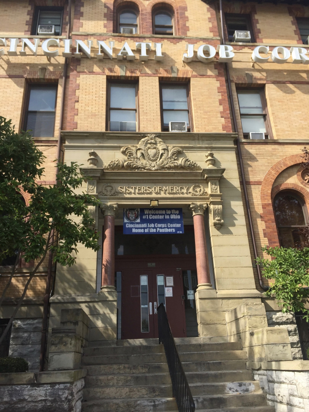Ein mehrst├Âckiges Geb├Ąude mit der Aufschrift "Cincinnati Job Corps Headquarters", Treppen, Gel├Ąndern, Pfeilern und umgebenden B├Ąumen.