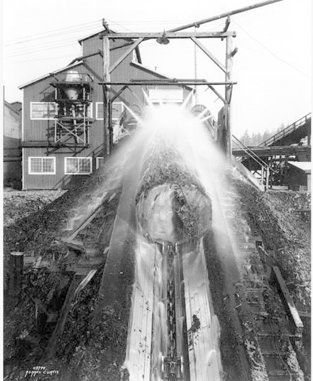 Schwarzes und weißes Foto eines Zuges, der auf Schienen mit einem Gebäude, Strommasten, Bäumen und Himmel im Hintergrund fährt, beschriftet mit "Curtis Coal Mine, Washington, D.C." unten.