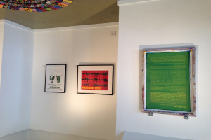 Drei Foto-Rahmen an einer Wand mit einem Objekt an der Decke in der linken oberen Ecke.