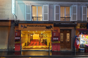 Das Theater Fontaine in Paris, Frankreich, ein Gebäude mit Fenstern, Türen, einem Schild, einem Straßenpfahl, Menschen, die davor stehen, Deckenleuchten, Regalen mit Gegenständen, einer Fahne und einer Kiste.