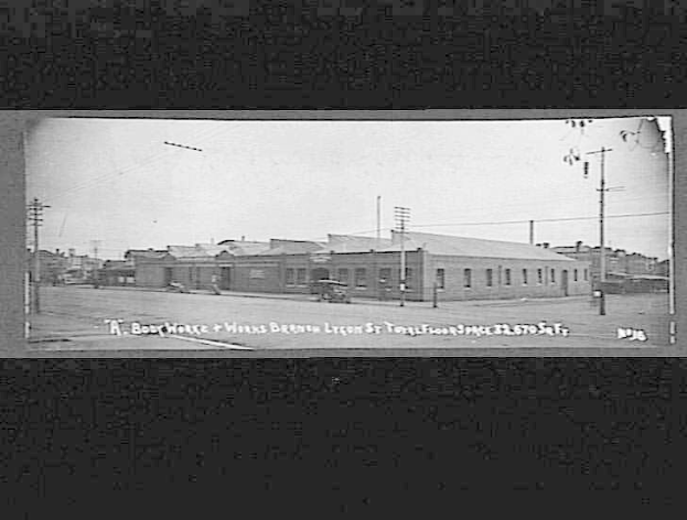 Schwarz-weiß-Foto einer Stadtstraße mit Gebäuden, Strommasten, Kabeln, Fahrzeugen und Himmel, beschriftet mit "Book House and Works, Bergen, Oregon" unten.
