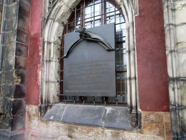 Steinbau mit Fenster und Holocaust-Gedenktafel mit Inschrift.