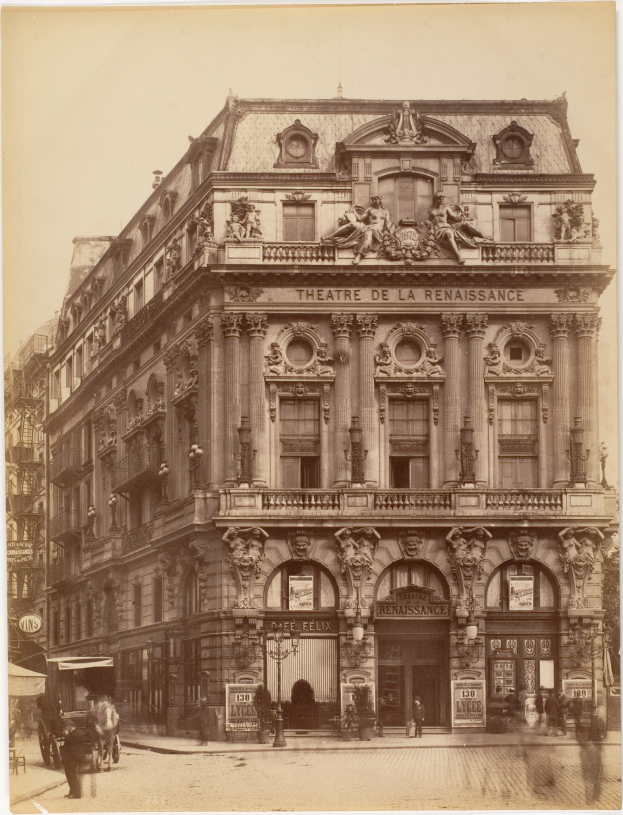 Altes Foto des Théâtre de la Renaissance in Paris mit seiner prächtigen Fassade, die von Fenstern, Säulen, Bögen und Skulpturen geschmückt ist, mit einigen Menschen und Fahrzeugen auf der Straße davor und dem Himmel im Hintergrund.