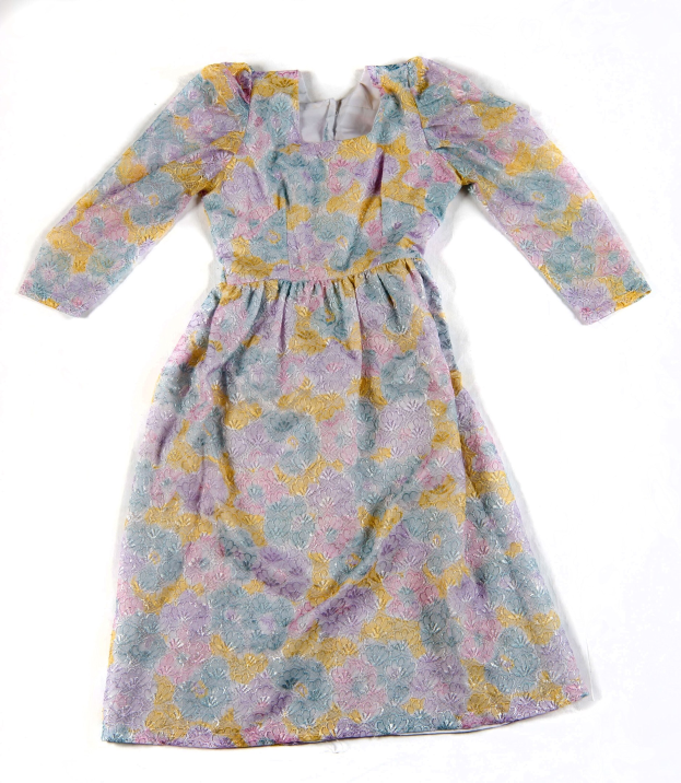 Ein lila und gelbes Blumenmuster-Kleid mit blauen Akzenten auf einem weißen Hintergrund.
