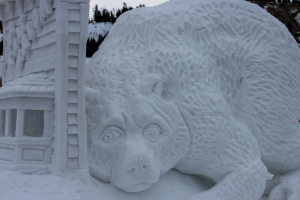 Schneekunst im Vordergrund mit ein paar Bäumen und dem Himmel im Hintergrund.