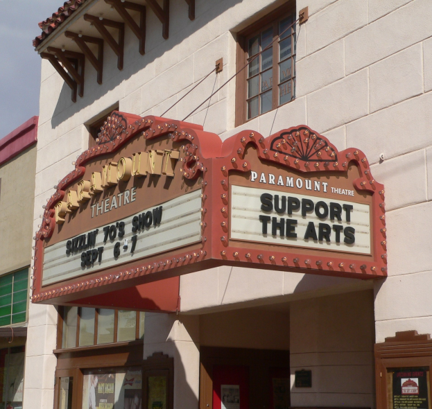 Außenansicht des Paramount Theatre in Sacramento, Kalifornien, mit Glasfenstern und -türen und einer 'Support the Arts'-Schrifttafel über dem Eingang sowie dem Himmel im Hintergrund.