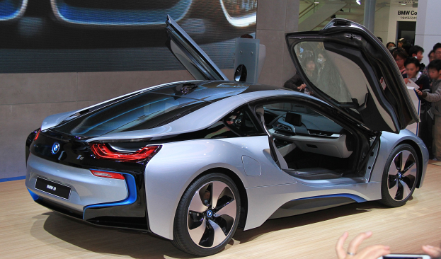 Ein BMW i8-Konzeptfahrzeug auf der Frankfurt Motor Show mit Menschen drumherum und einer Person mit einem Handy im Vordergrund.