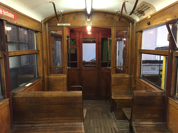 Ein hölzerner Zuginneneinrichtung in Berlin, Deutschland, mit hölzernen Sitzen, Glasfenstern, Türen, Lampen und anderen Gegenständen.