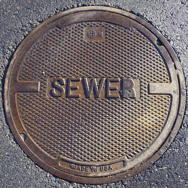 Metallschachtdeckel auf der Straße beschriftet mit "Kanal".