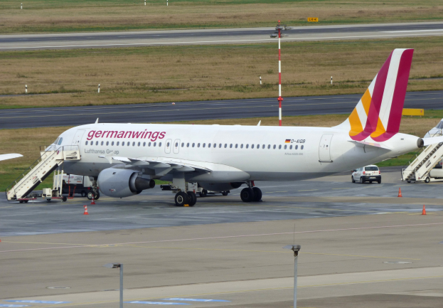 Germanwings Airbus A320-200 am Frankfurt Airport mit Bodenfahrzeugen, Verkehrskegeln, Pfählen und Gras im Hintergrund geparkt.