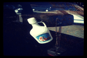 Ein Auto steht am Straßenrand mit einer Kette und einer Flasche in der Nähe.