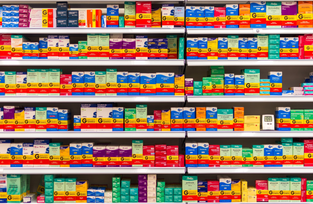 Ein Apothekenschrank mit verschiedenen Boxen und Medizinbehältern, die ordentlich auf Regalen angeordnet sind.