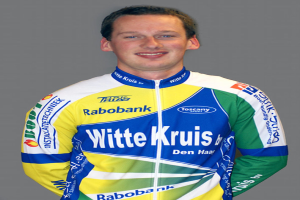 Ein Sportler in Pose vor einer Kamera, der ein Trikot mit verschiedenen Sponsorennamen trägt.