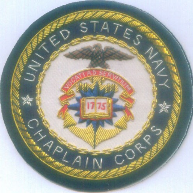 Rundes Abzeichen mit blauem Hintergrund, weißer Umrandung und weißer, mittig gesetzter Schriftzug "United States Navy Chaplain Corps."