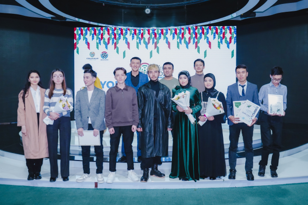 Gruppe von Menschen auf einer Bühne mit Blumensträußen und Urkunden, im Hintergrund ein "Youth Solar Awards 2019"-Schild.