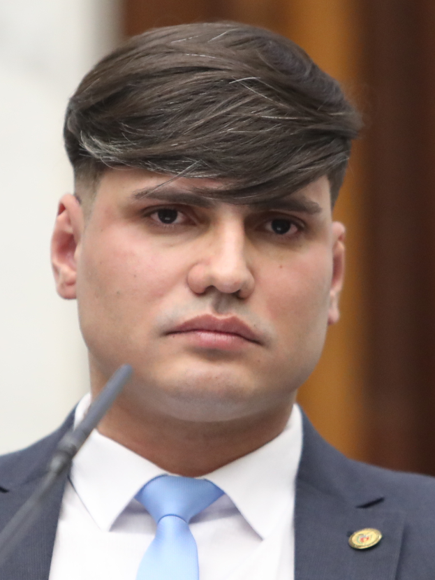 Rep. Devin Nunes, dressed in a suit and tie, speaks into a microphone with a blurred background.