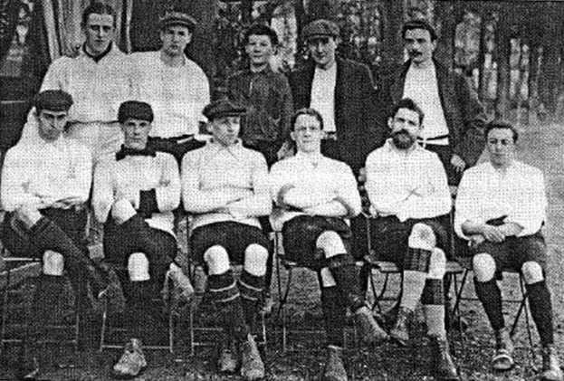 Schwarze und weiße Mannschaftsfoto des West Bromwich Albion Football Club aus dem Jahr 1918, mit sitzenden und stehenden Spielern und Bäumen im Hintergrund.