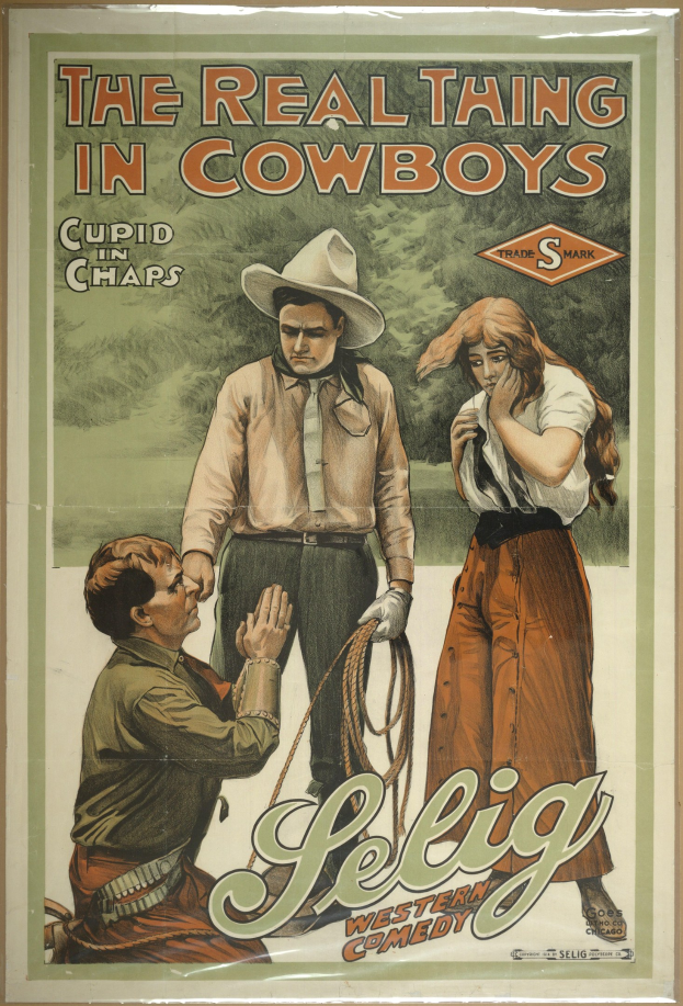 Plakat an einer Wand mit drei Personen in Cowboy-Kleidung und dem Text "The Real Thing in Cowboys" darüber, vor einem hellgelben Hintergrund.