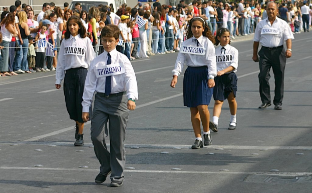 Menschen auf einer Straße während eines Ereignisses, tragen Abzeichen und sind von einer großen Menge umgeben.