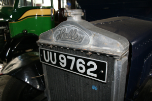 Nahaufnahme eines Triumph Herald-Autoabzeichens mit unscharfem Hintergrund.