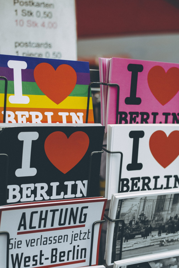 Ein Regal mit Bücher und Postern mit der Aufschrift "Ich liebe Berlin" vor einem leicht unscharfen, träumerischen Hintergrund.